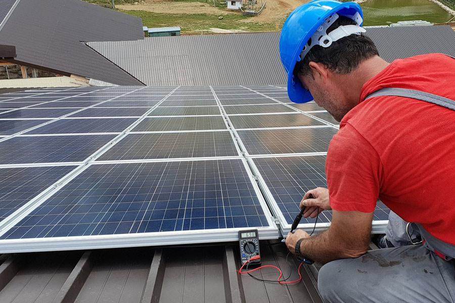 Image of a solar installer work with a solar panel using solar installation tools, depicting all you need to know about solar installation tools