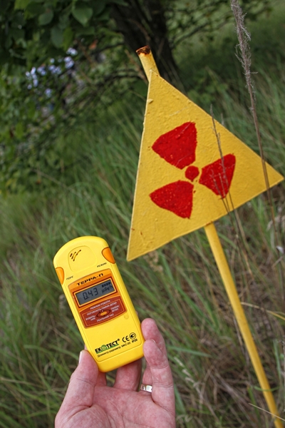 A radiation detector alongside a radiation sign in the woods